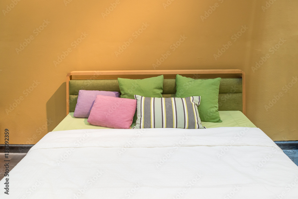 Bedroom interior with bed and colorful pillow of cosy home