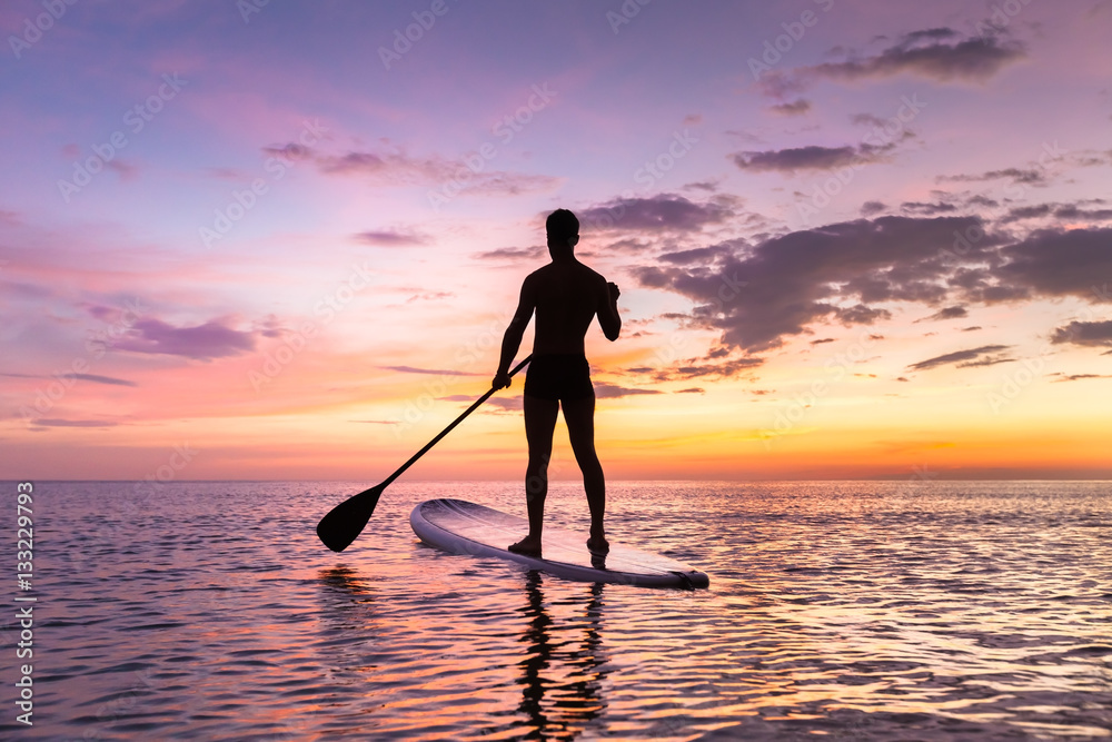 Person stand up paddle boarding, dusk, quiet sea, sunset colors