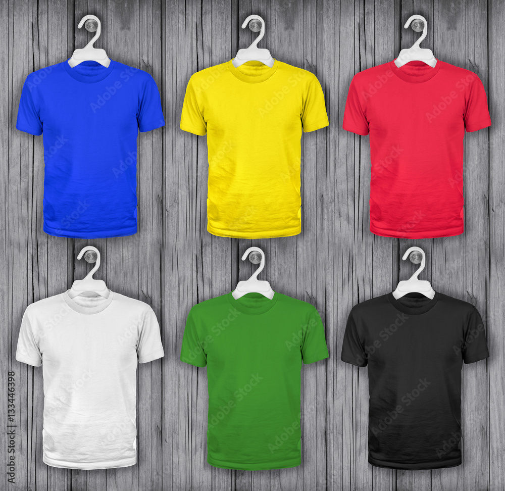 colored t-shirts hanging on a wooden wall