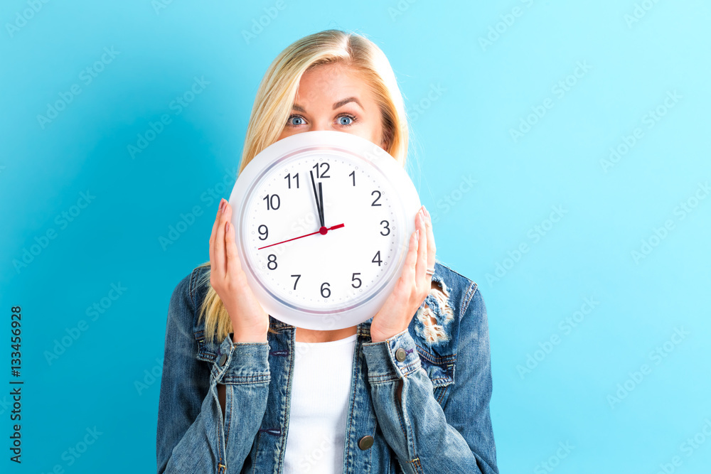  Woman holding clock showing nearly 12