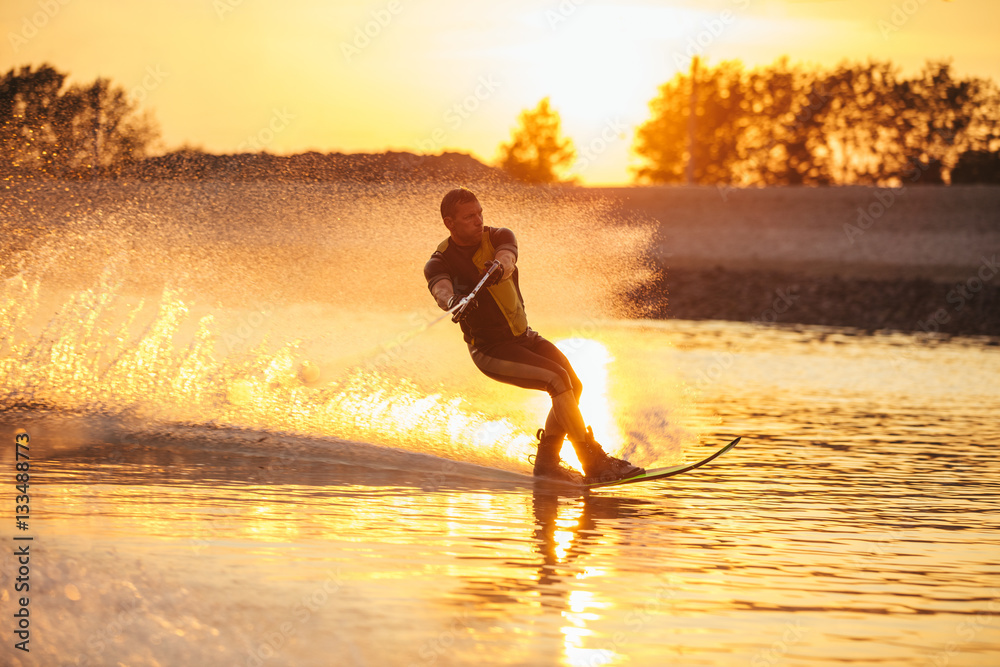 Man water skiing at sunset