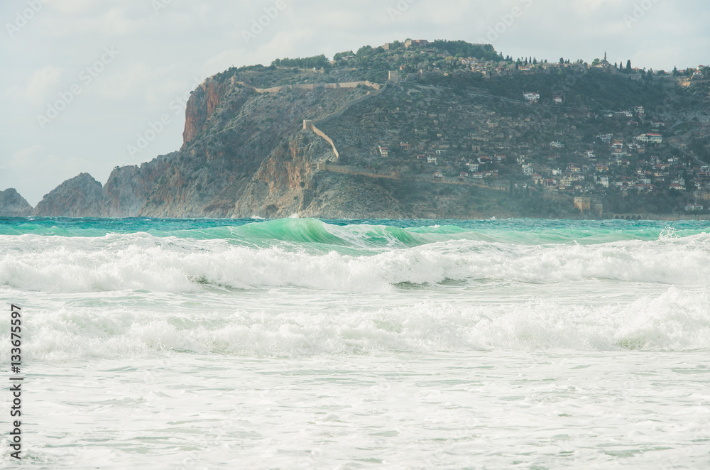 Stormy Mediterranean sea in winter in Alanya, Turlkey. View over Alanya castle hill and waves on cle