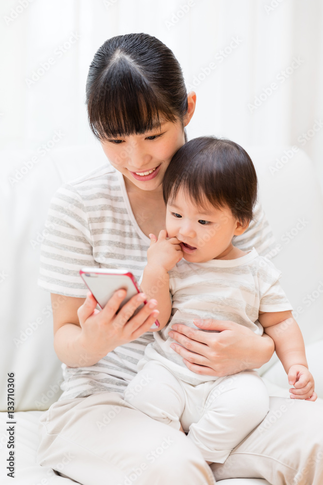 asian mother and baby using smart phone