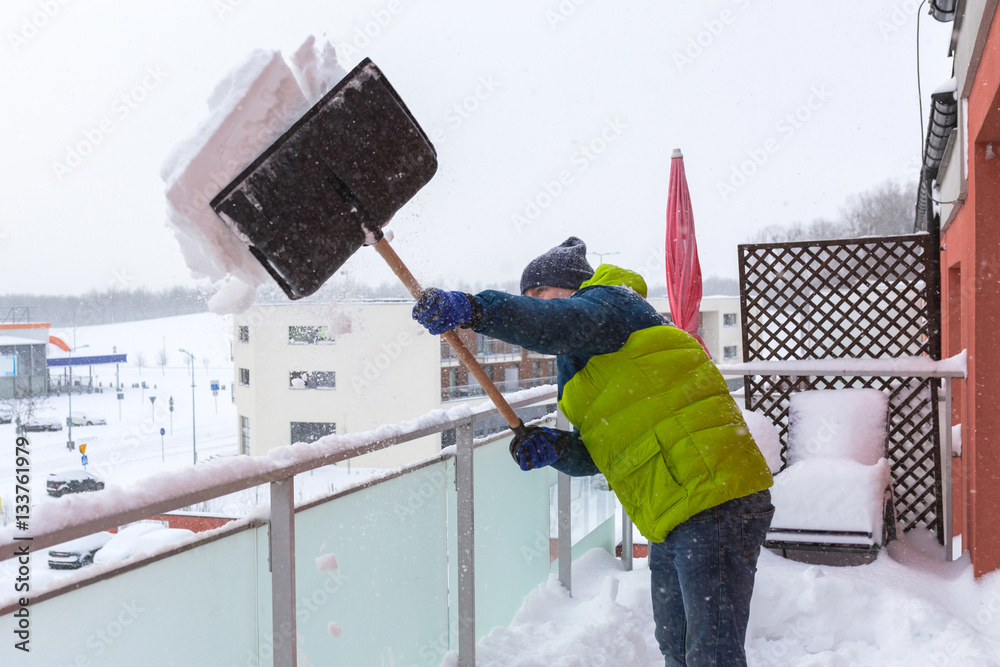 大雪过后，男子在露台上铲节目