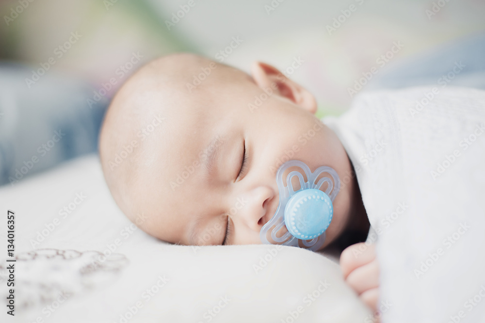 亚洲男婴在卧室里用奶嘴平静入睡