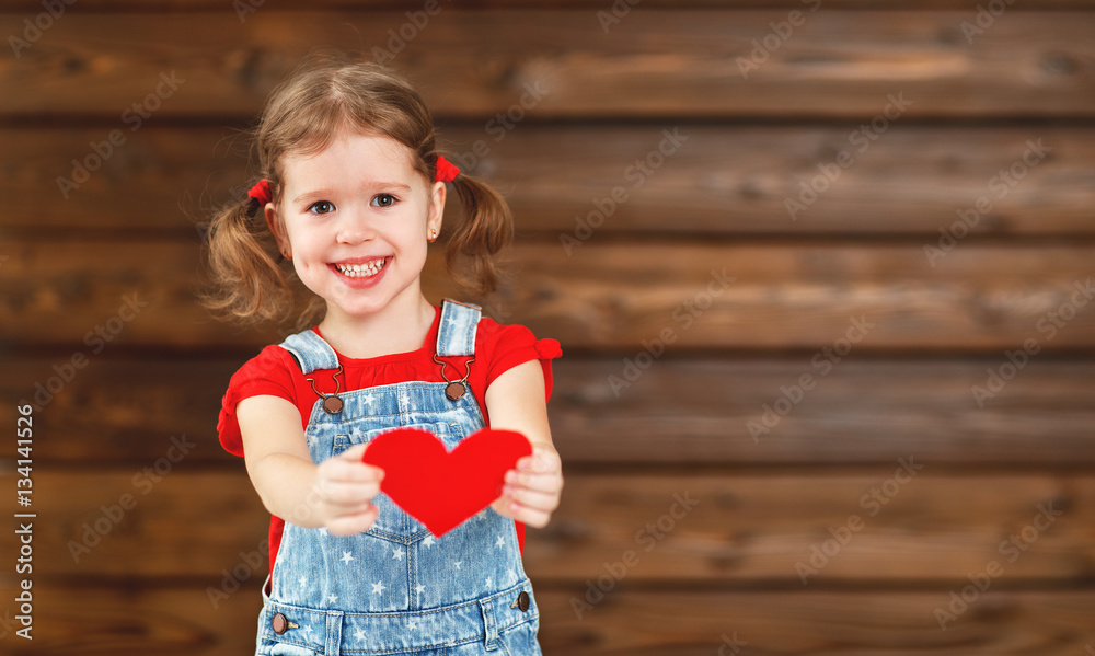 happy laughing child girl with heart Valentines Day, wooden