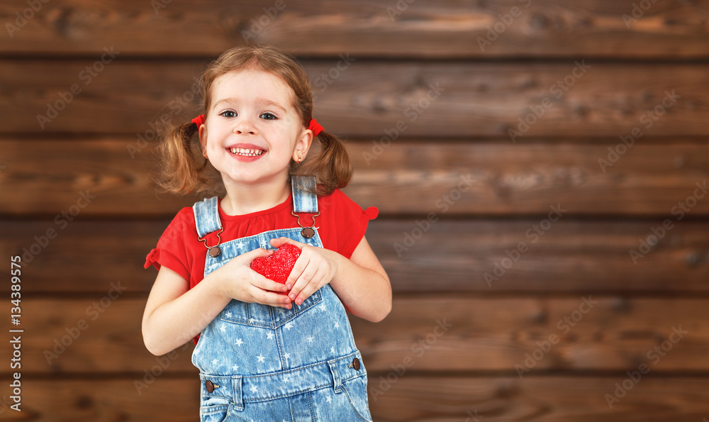 happy laughing child girl with heart Valentines Day, wooden