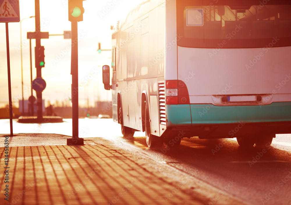 清晨在城市道路上行驶的公交车。用红绿灯和交通工具观察交通