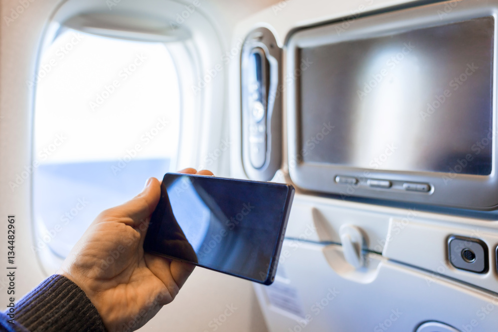 Hand with smartphone to watch movies during the flight