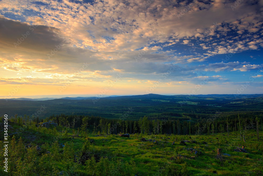 Bountiful morning sunrise in the Sumava Mountain, chop down forest on the hill, nice clouds on the s