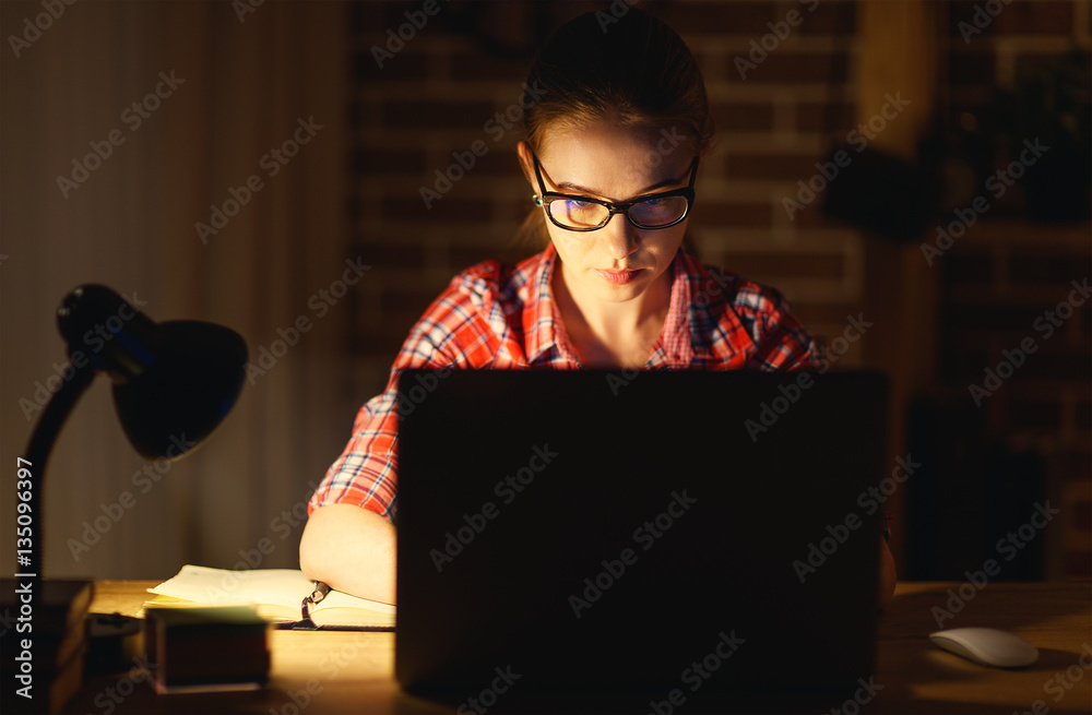 young woman student working on the computer at night
