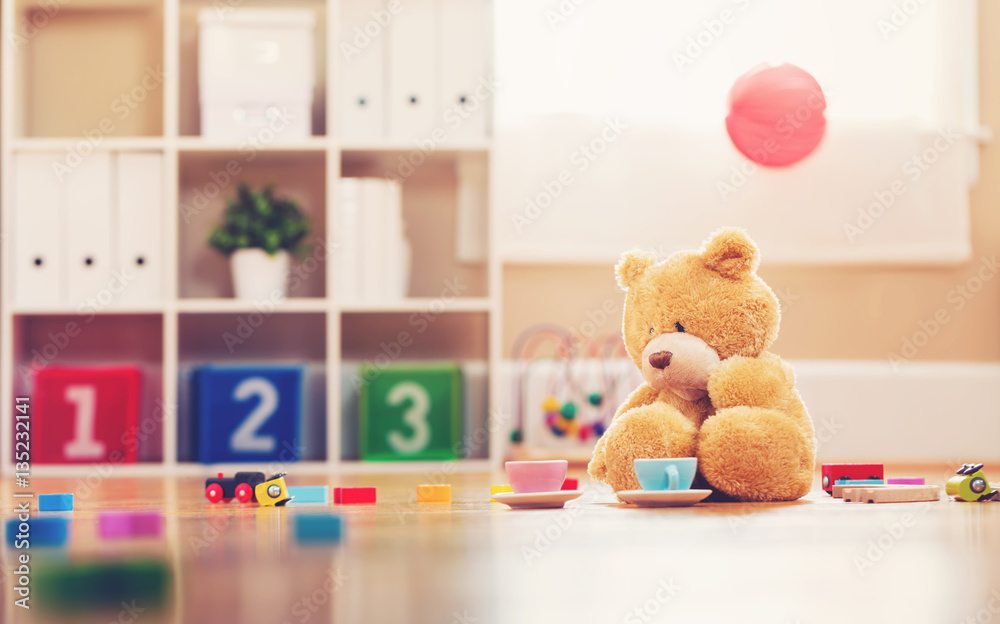 Teddy bear surrounded by toys
