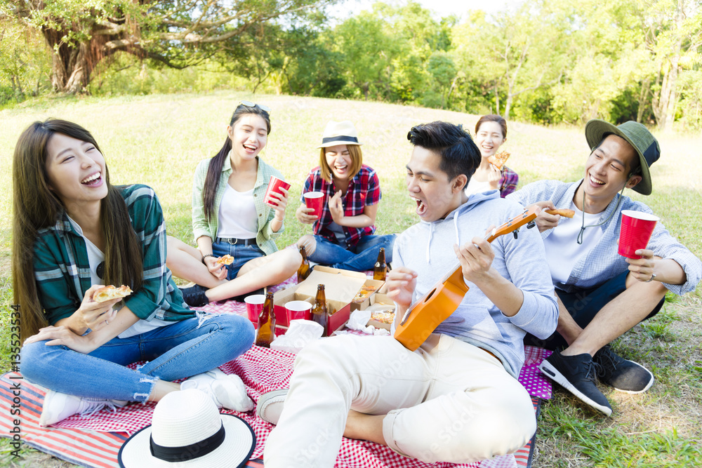 快乐的年轻朋友团享受野餐派对