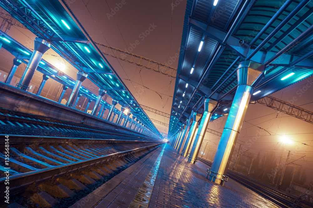 夜晚的火车站。雾中的火车站台。铁路