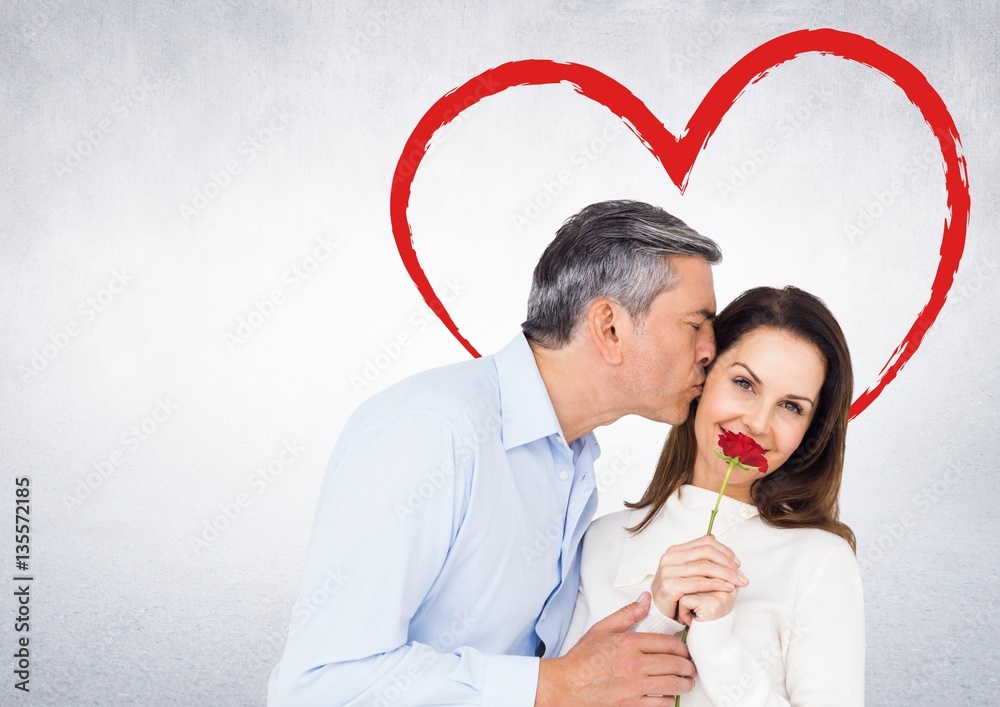 Mature man kissing woman holding a rose