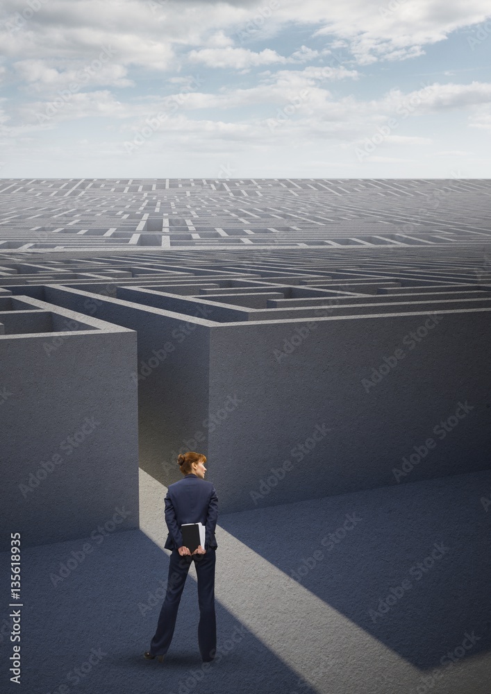 Businesswoman standing outside a maze