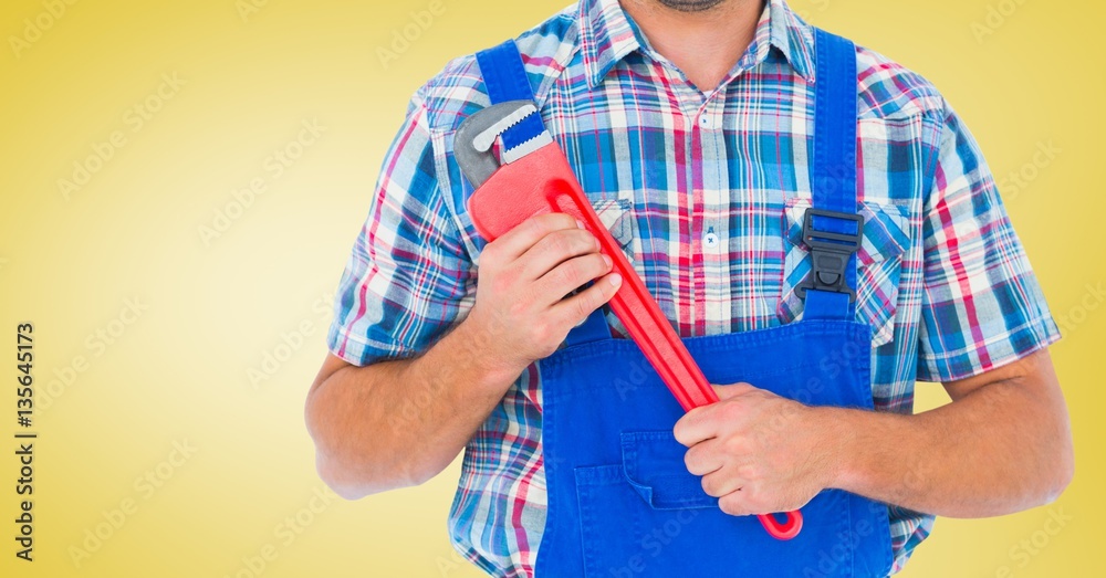 Mid section of handy man holding wrench