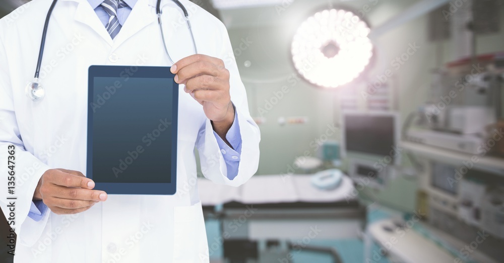 Mid section of doctor standing with digital tablet