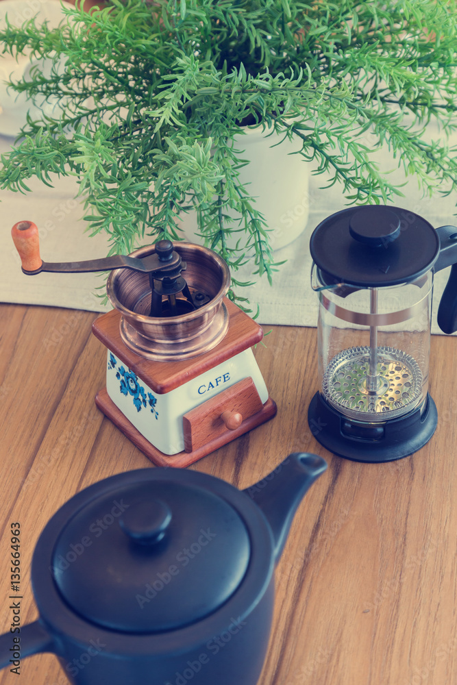 set of tea or coffee with small teapot on wooden table with room