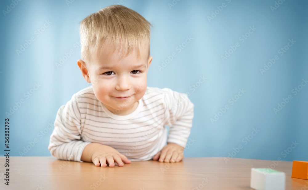 一个坐在桌子旁的两岁孩子的肖像