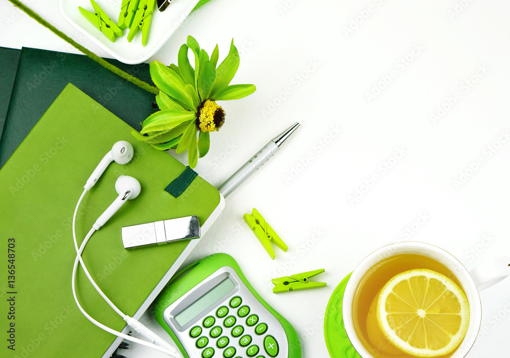 Set of objects on table for girl in light green colors. Tea with lemon, notebook, headphones, USB fl