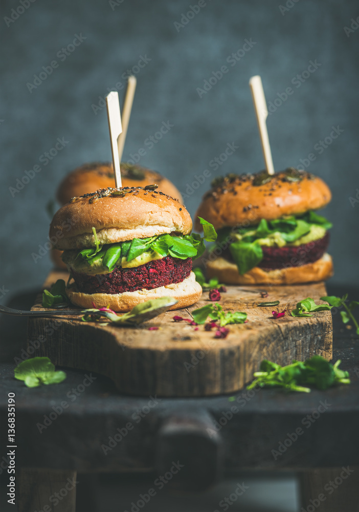 Healthy vegan burgers with beetroot and quinoa patty, arugula, avocado sauce, wholegrain buns on rus