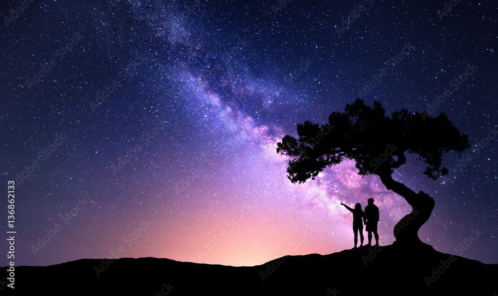Milky Way with people under the tree on the hill. Landscape with night starry sky and silhouette of 