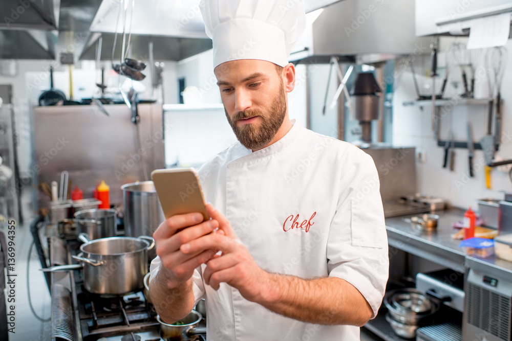 厨师在餐厅厨房使用智能手机做饭
