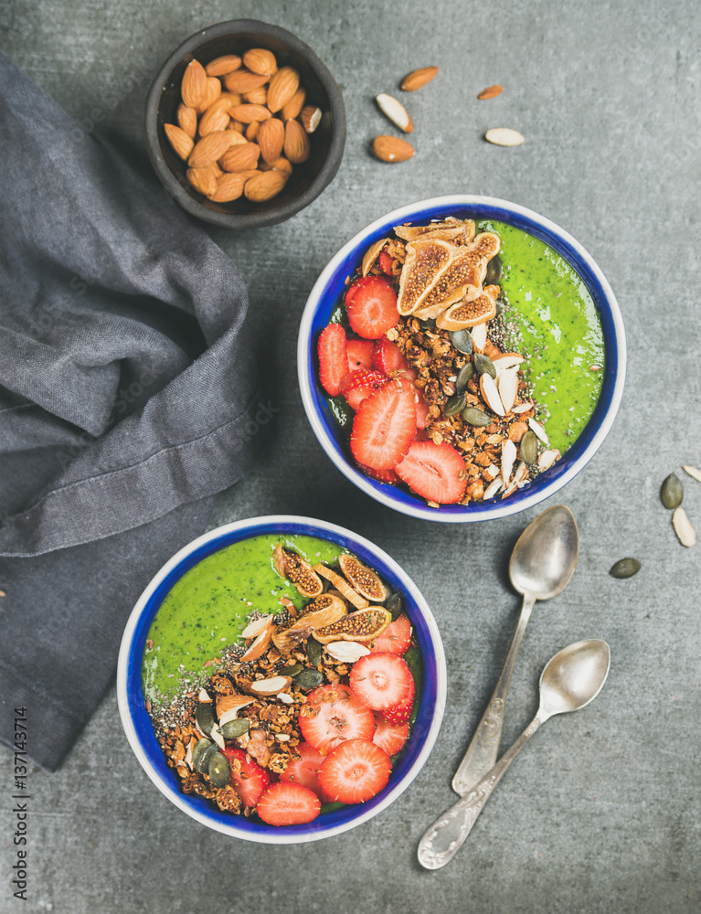 Healthy breakfast. Green smoothie bowls with strawberries, granola, chia and pumpkin seeds, dried fi