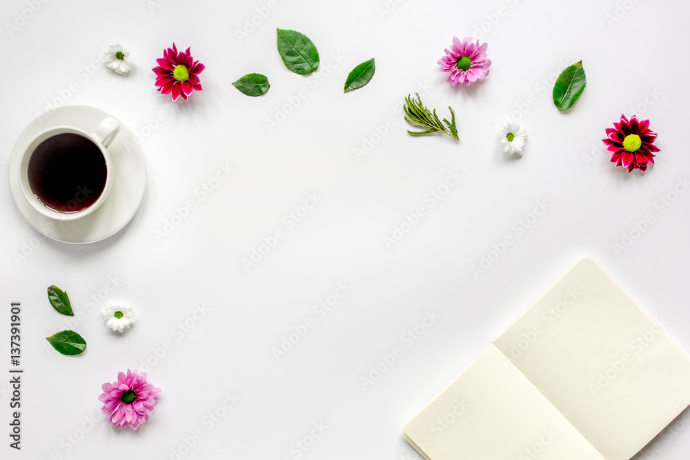 Petals, cup and copybook on table background top view mock up