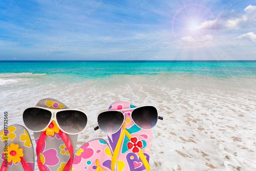 beach shoes with sunglasses on tropical sea and sky background.