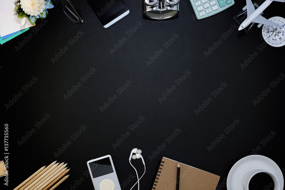 带智能手机、用品和咖啡杯的办公室黑色皮革办公桌，办公配件，俯视图