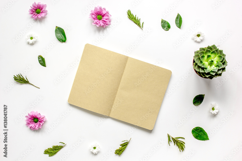 Notebook with flower petals on white table background top view mock-up