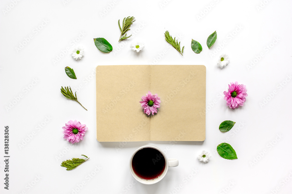 Petals, cup and copybook on table background top view mock up