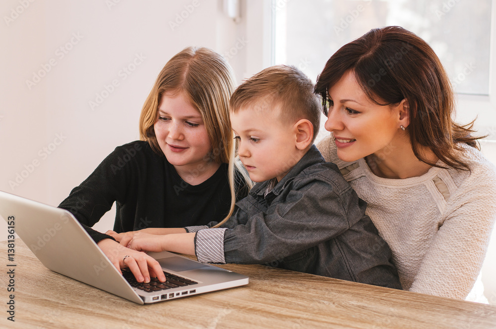 Mom and kids having fun on laptop at home