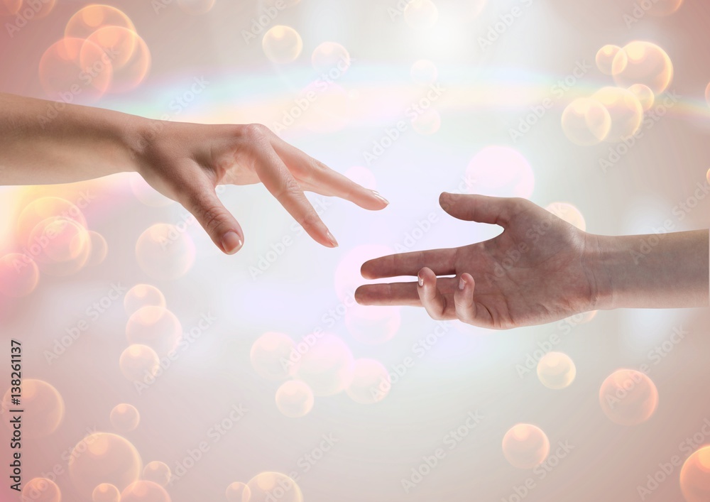 Composite Image of two Hands against a shining background