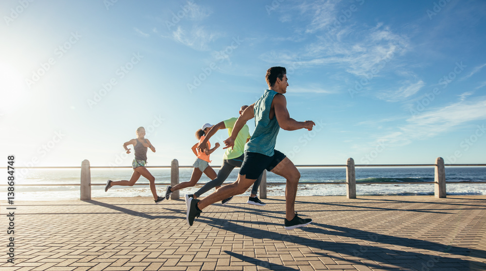 Young runners sprinting on the ocean front path