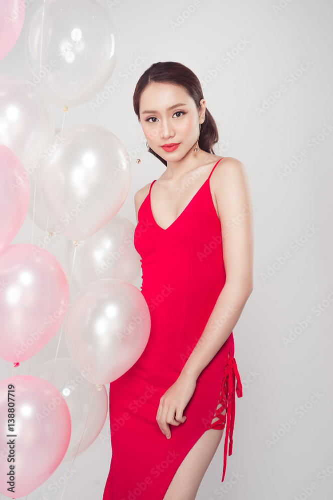 Asian fashion woman smiling and looking at camera with balloons background.