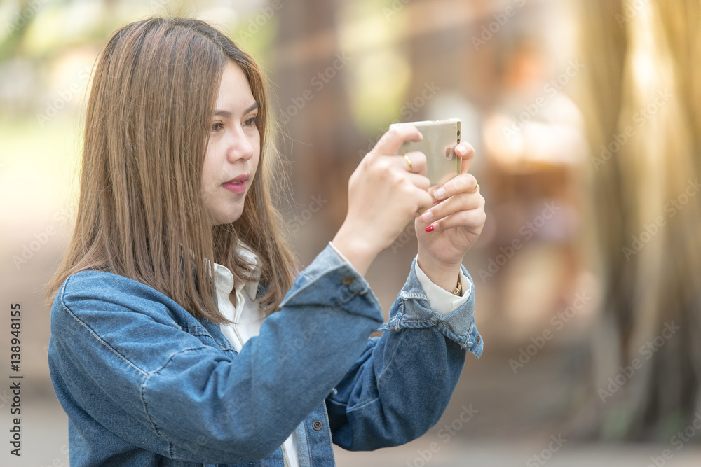 年轻女子用手机拍照。
