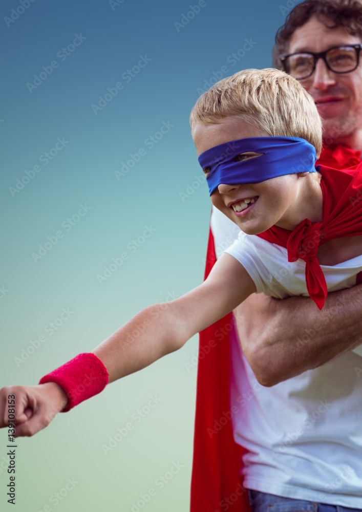 Father carrying a son in super hero costume