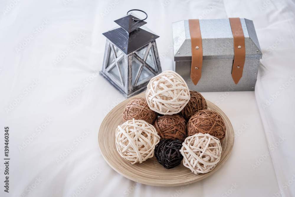 decorate items with weave rattan ball and vintage lantern  with old metal box on white bedsheet in d