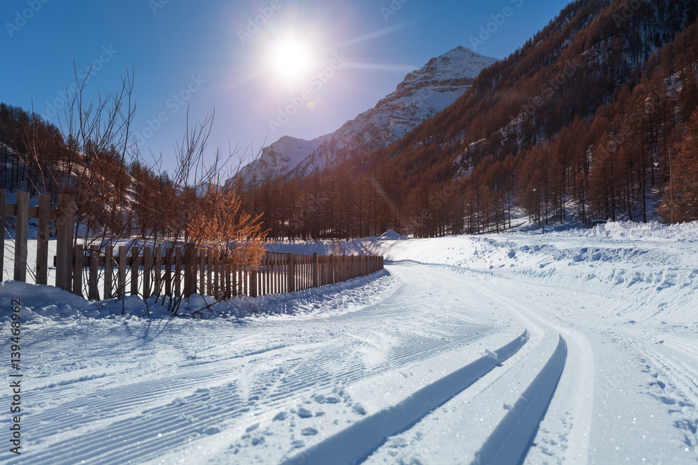 Snowcapped road to ski resort with snowcat tracks