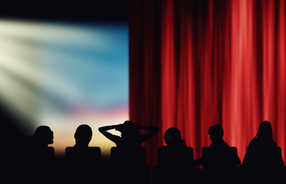 Silhouettes of cinema spectators watching movie