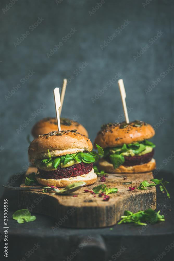 Healthy vegan burgers with beetroot and quinoa patty, arugula, avocado sauce, wholegrain buns on rus