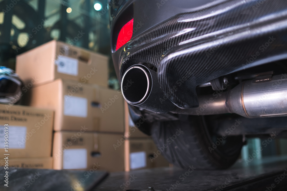 Close up sport car carbon fiber exhaust pipe in garage
