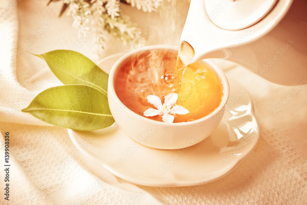 Close up pouring hot jasmine tea in a white tea cup ,  Tea ceremony time concept , vintage color ton