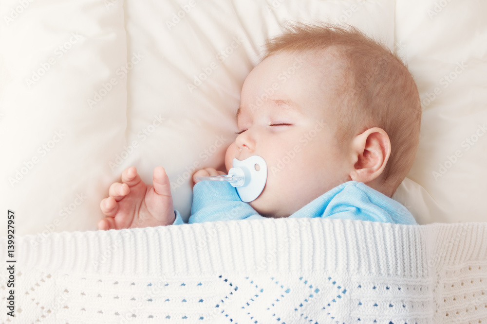 婴儿睡在蓝色毯子上