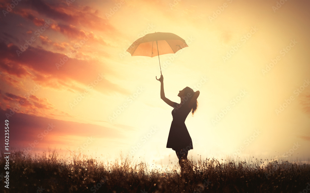 美丽的年轻女子在美妙的阳光背景下撑着伞的影子