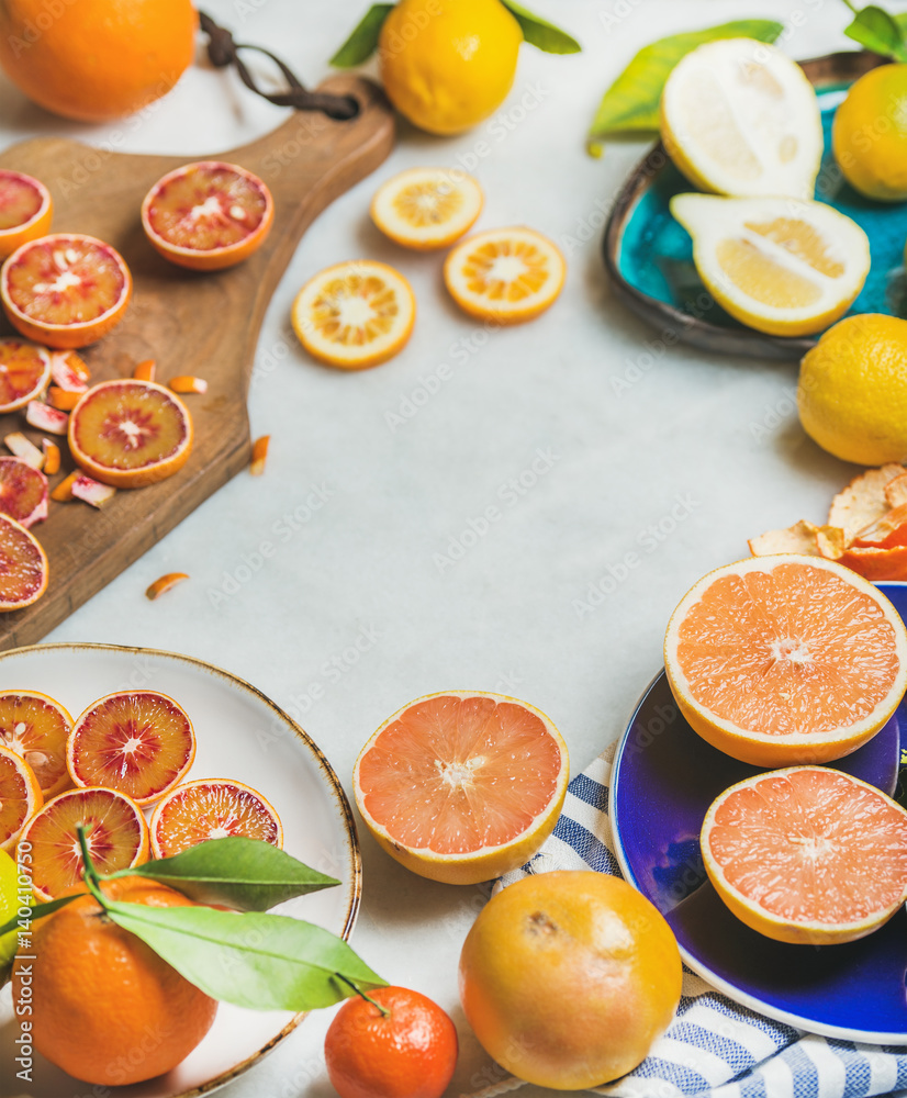 彩色陶瓷板和灰色大理石上的木制乡村砧板中的天然新鲜柑橘类水果