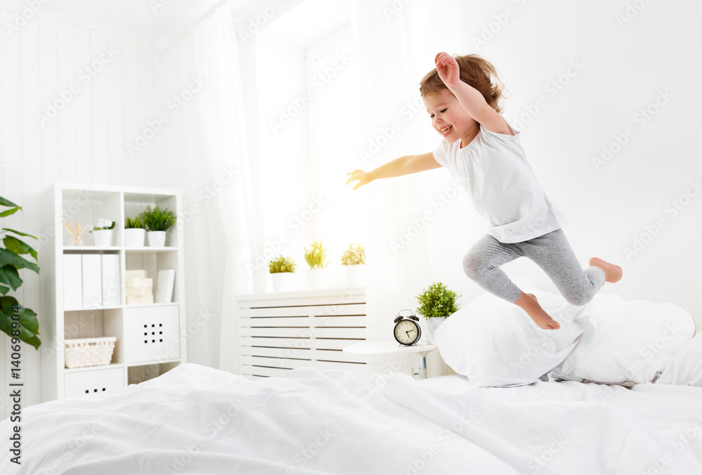 快乐的小女孩跳起来玩床